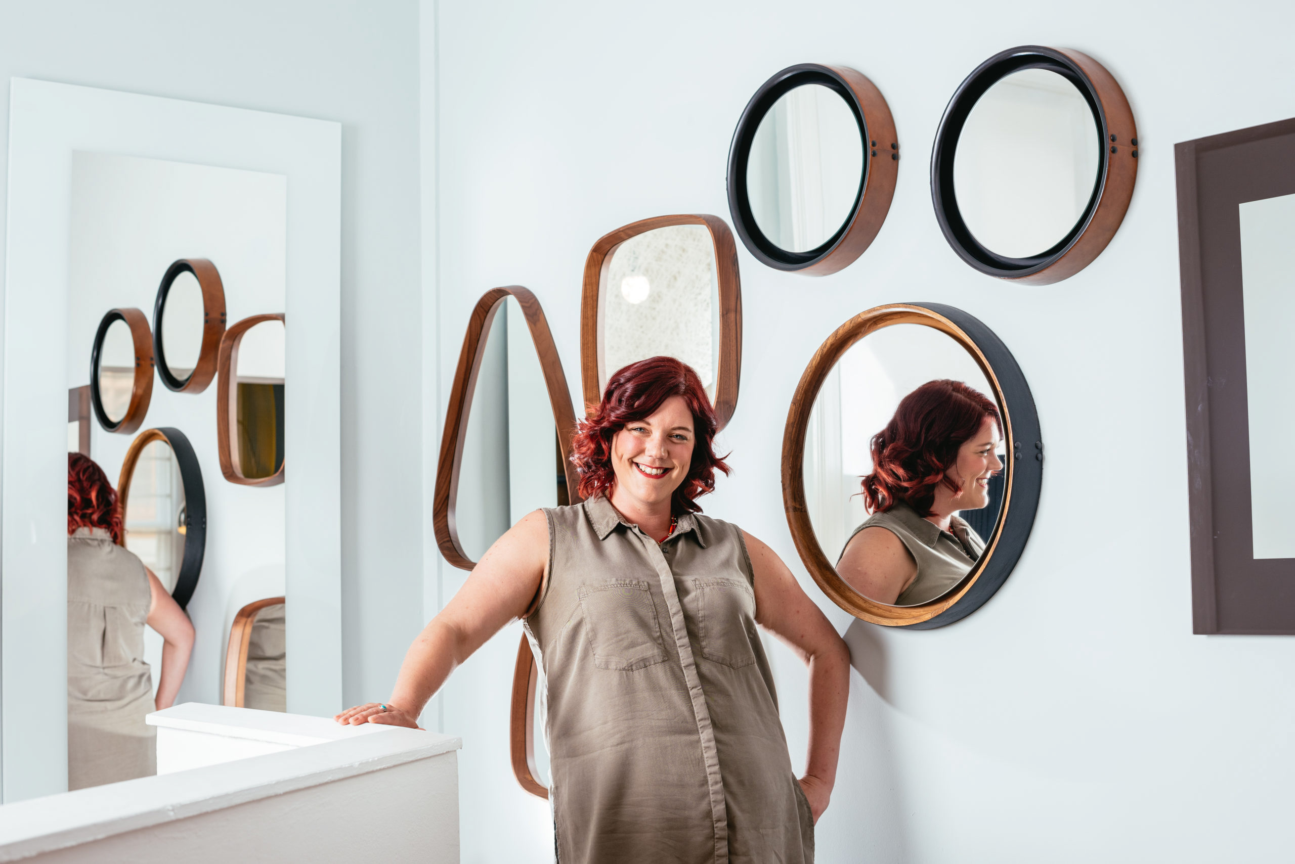 portrait of a lady in front of a wall of mirrors