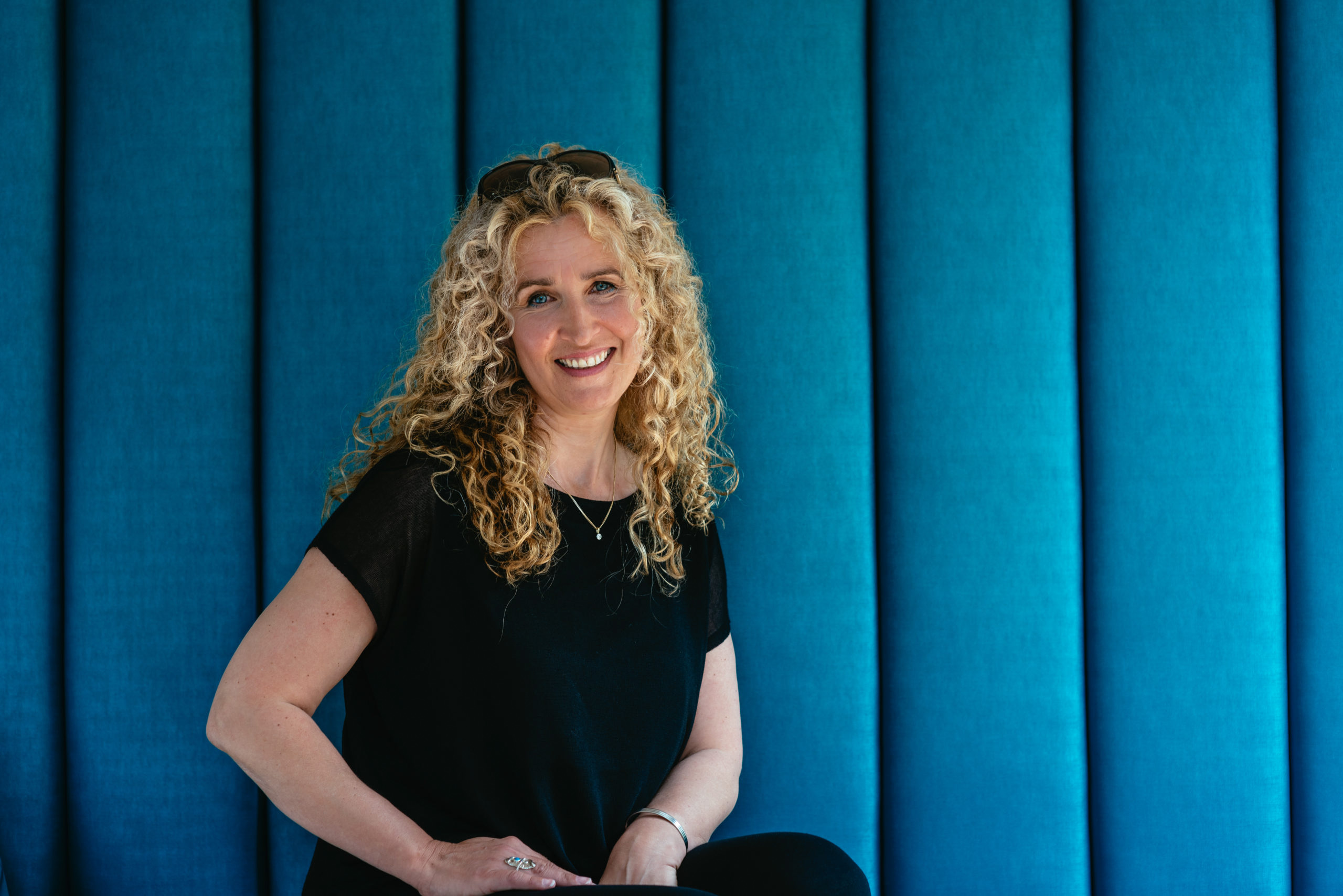 headshot of a lady with long blonde curly hair