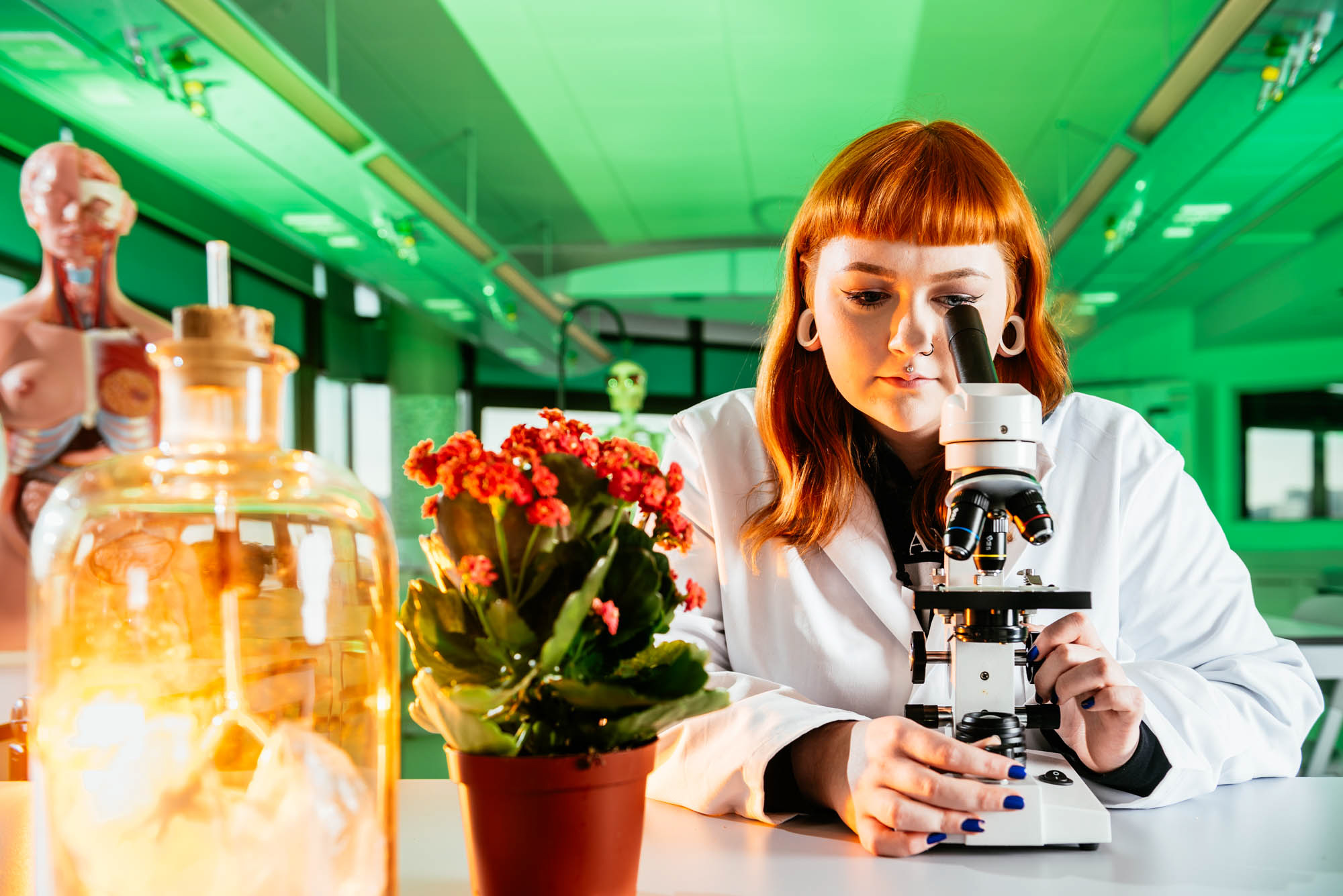 Female student using a microscope in a lab